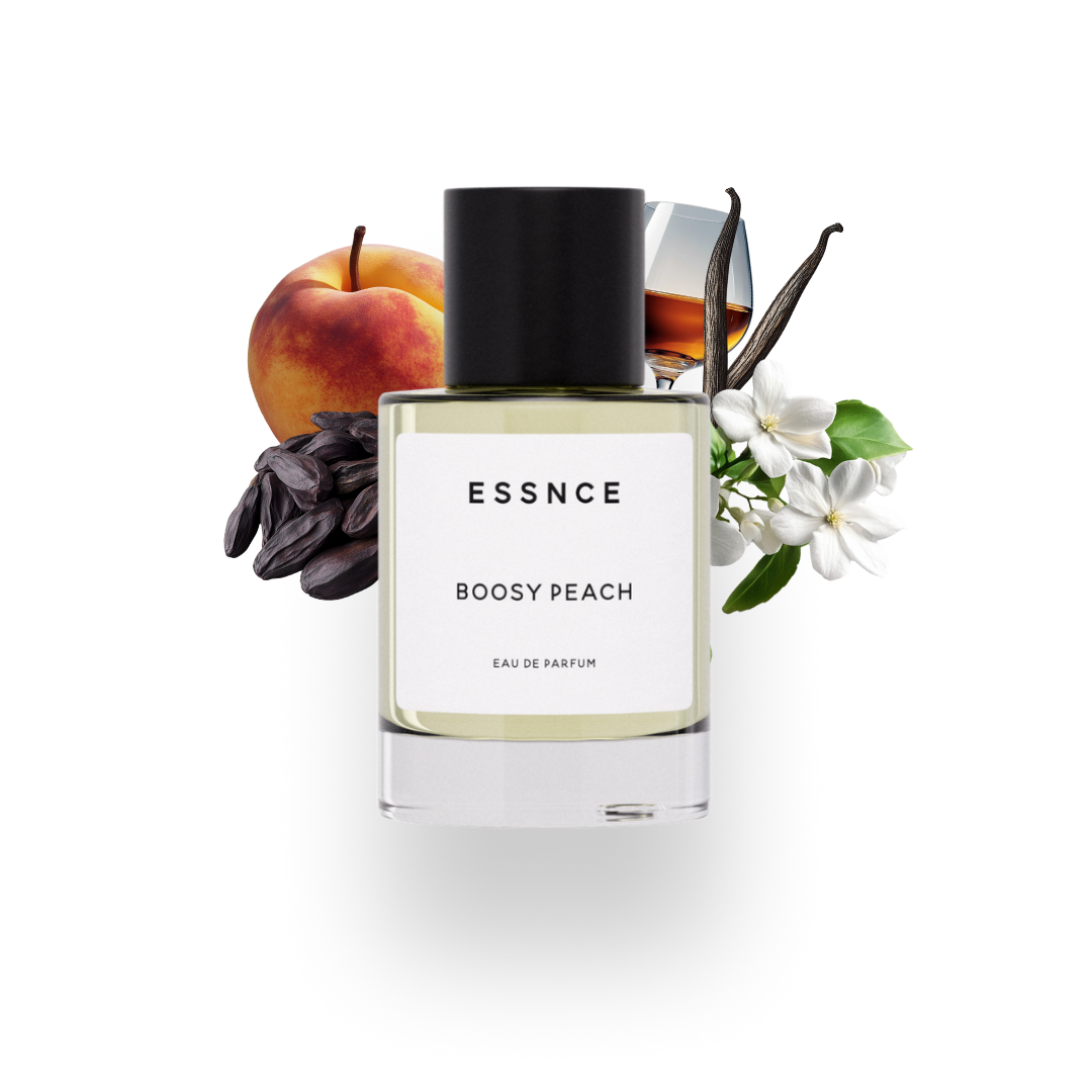 En flaska ESSNCE Boosy peach Eau de Parfum visas med en svart kork och en vit etikett. Bakom flaskan finns ingredienser som persika, vanilj, tonkaböna, jasmin och ett glas konjak.