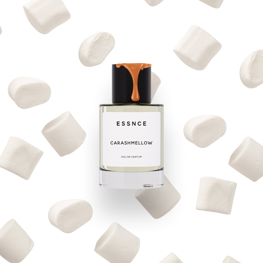 En flaska ESSNCE Carashmellow Eau de Parfum med kolasås som rinner ner över korken. Bakgrunden är vit med marshmallows som regnar ner.