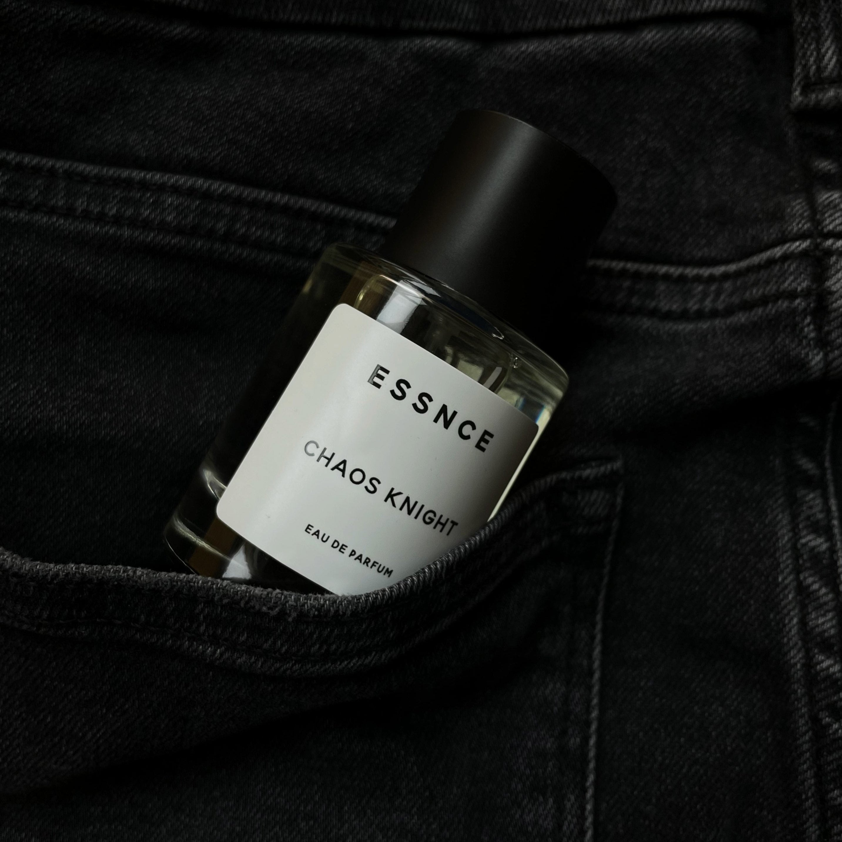 En flaska ESSNCE Chaos Knight Eau de Parfum visas uppstickandes från en jeansficka.