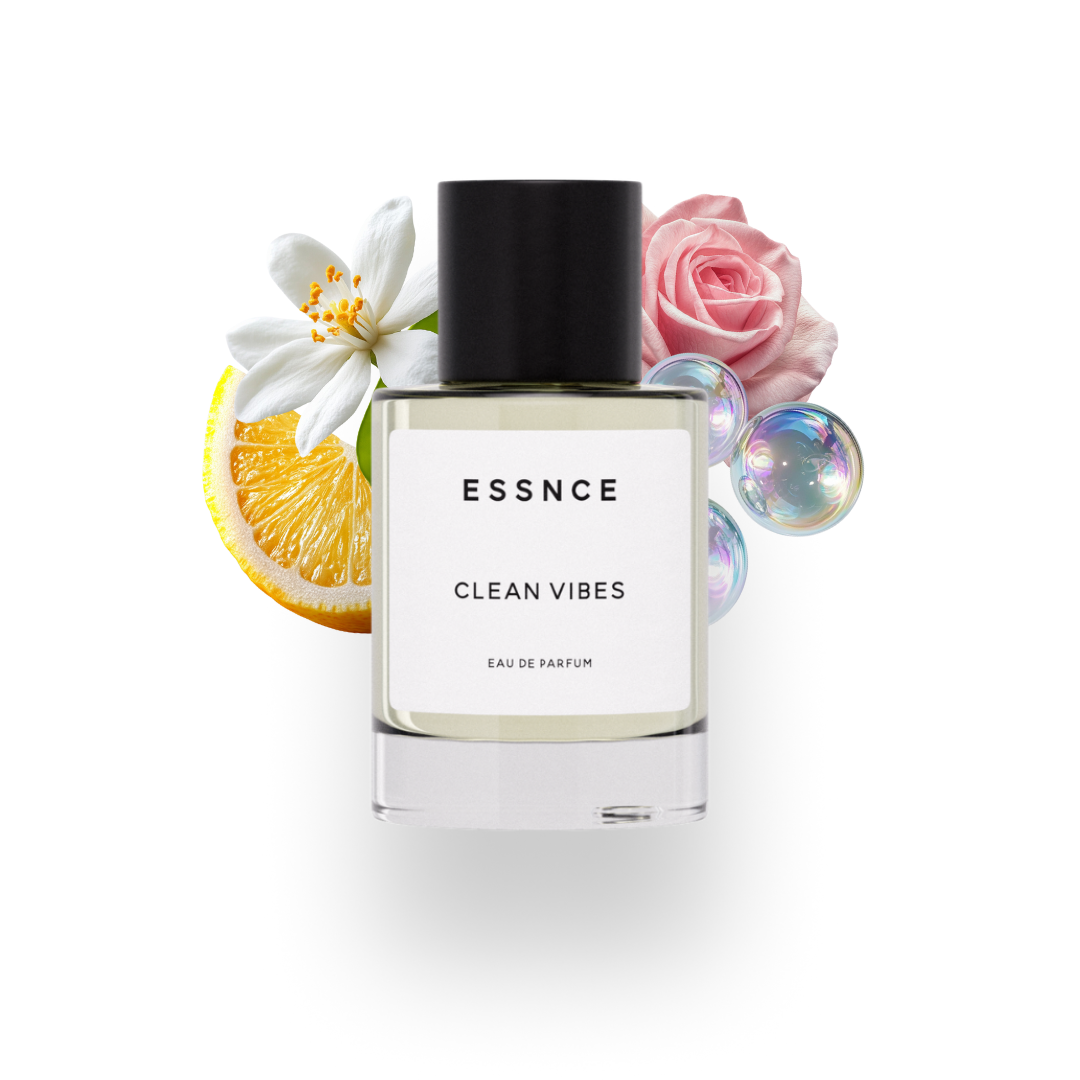 En flaska ESSNCE Clean vibes Eau de Parfum visas med en svart kork och en vit etikett. Bakom flaskan finns ingredienser som sopa, ros, apelsinblomma och citron.