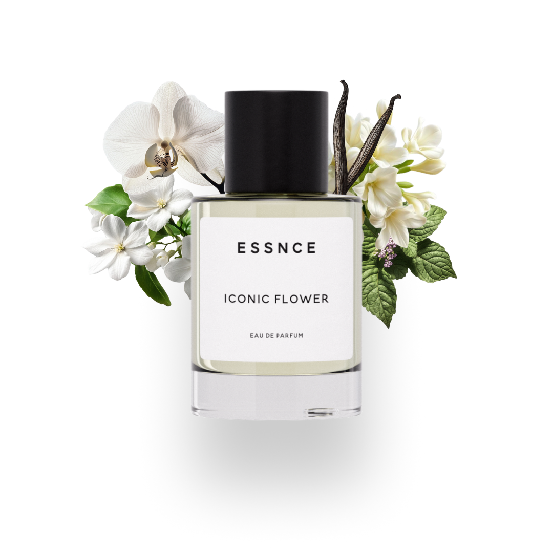 En flaska ESSNCE Iconic flower Eau de Parfum visas med en svart kork och en vit etikett. Bakom flaskan finns ingredienser som Jasmin, Tuberose, orkidé, patchouli och vanilj.