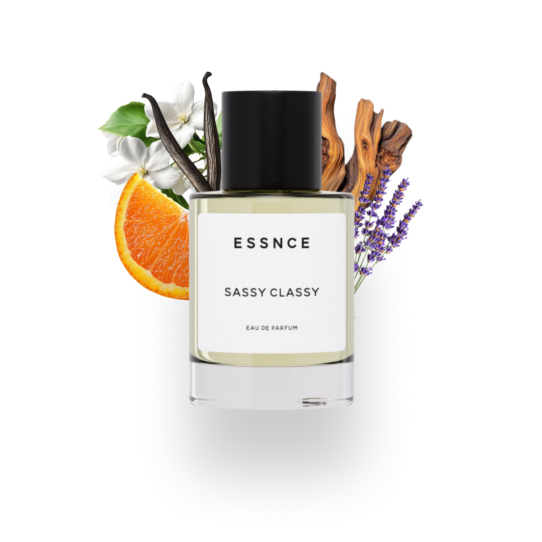 En flaska ESSNCE Sassy classy Eau de Parfum visas med en svart kork och en vit etikett. Bakom flaskan finns ingredienser som jasmin, apelsin, cederträ, lavendel och vanilj.